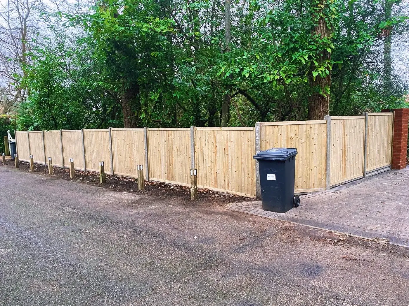 Closeboard fence installation completed in a garden