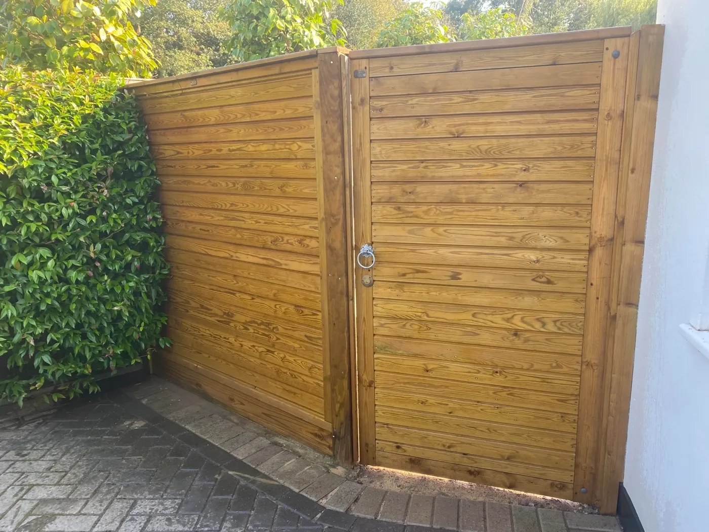 Tongue and groove timber garden gate hung between fence posts